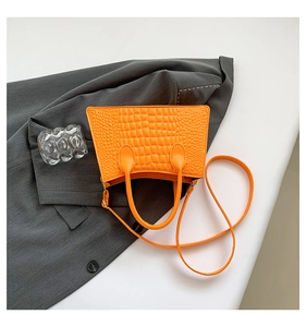Detailed view of orange crocodile pattern PU leather handbag with detachable shoulder strap