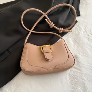 Détail du sac baguette en similicuir rose avec boucle dorée et bandoulière nouée