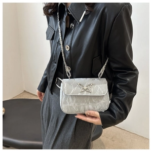 Detail view of marble texture leather flap bag with silver butterfly metal buckle and chain