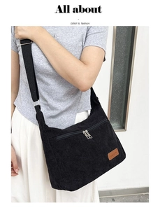 Detail showing soft black corduroy texture and adjustable strap on the crossbody bag