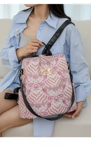 Asian model carrying a printed backpack with wave patterns and golden bow detail