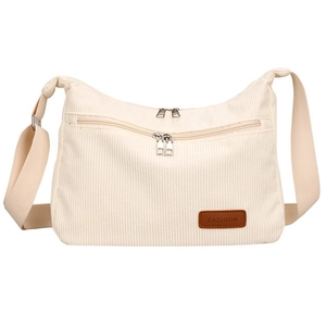 Close-up of beige corduroy crossbody bag featuring a leather logo patch and silver zippers