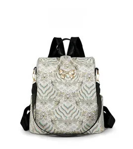 Front view of large retro print backpack with white gold jacquard and metal bow