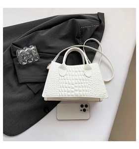 Detailed close-up of white crocodile pattern PU leather handbag with gold hardware details