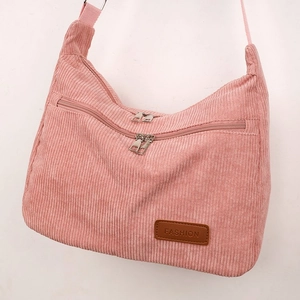 Detailed view of pink corduroy shoulder bag featuring zip pockets and fashion leather patch