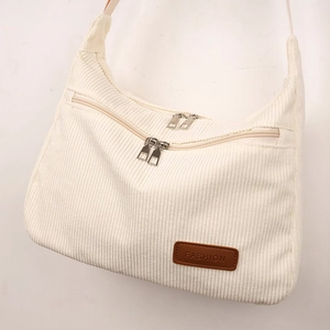 Detail of off-white corduroy shoulder bag with brown leather label and double zip pockets