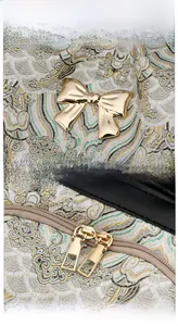 Detail view of jacquard fabric with traditional patterns and golden metal bow decoration