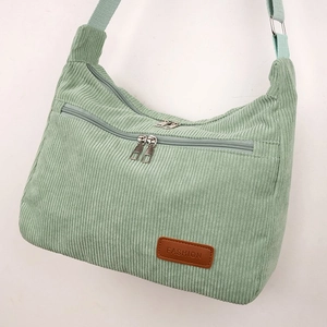 Close-up of mint green corduroy crossbody bag texture with fashion leather patch