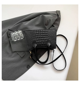 Close-up of black crocodile-embossed PU leather texture and gold-tone hardware details