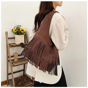 Gedetailleerd beeld van bruine suède tas met franjes in een bohemien vintage stijl