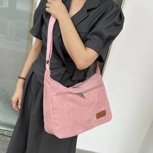 Pink corduroy crossbody bag with adjustable strap and fashion label for women's daily commute
