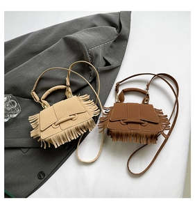 Sacs à franges beiges et marron foncé disposés sur un blazer gris pour un look chic