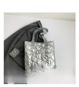 Silver quilted tote bag with diamond pattern and light gray woven handle detail