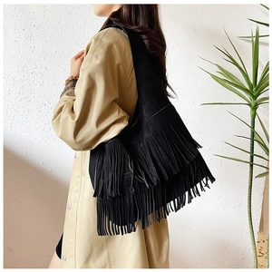 Detailweergave van zwarte suède schoudertas met lange franjes en bohemien uitstraling