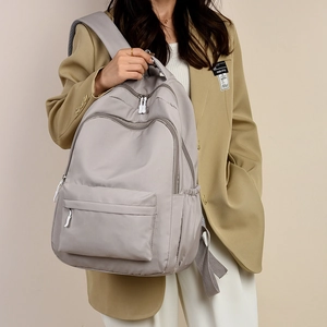 Light grey large capacity backpack with multiple zippers for travel and school use