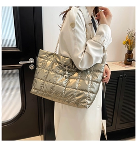 Close-up of champagne gold quilted tote bag with metallic finish and chain strap