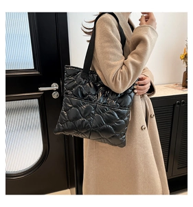 Close-up of a black quilted tote bag with glossy finish and large capacity for daily use