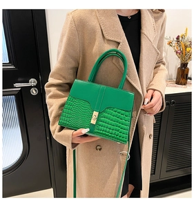 Détail du sac à main vert émeraude avec motif pierre et fermoir métallique doré brillant