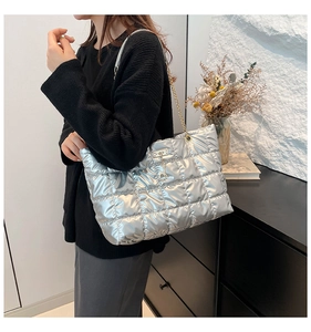 Close-up of quilted silver tote bag with metallic finish and gold chain strap
