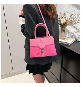 Détail d'un sac bandoulière rose vif avec coutures en relief et boucle en métal