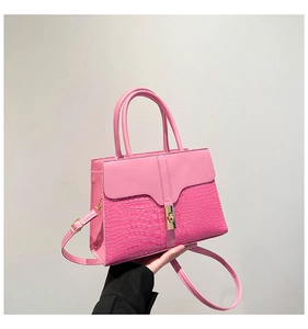 Detail of pink stone pattern textured handbag featuring a gold turn-lock closure
