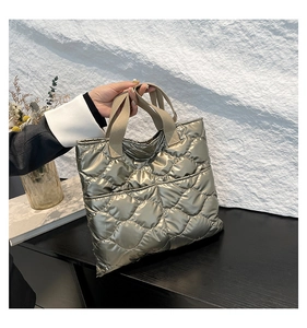 Close-up of olive gold quilted tote bag showing waterproof texture and front pocket