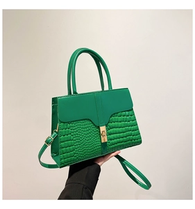 Close-up of green stone pattern crossbody bag with golden metal twist lock and strap