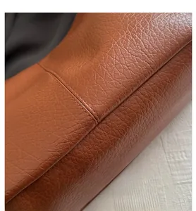 Close-up of caramel lychee grain leather texture with precision double-stitch detailing