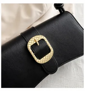 Primer plano de bolso de hombro de cuero negro con hebilla dorada y detalle de nudo