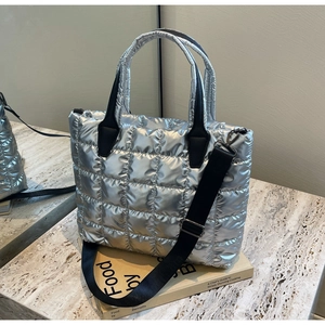 Detail view of silver quilted tote bag with square down padding and metal gloss texture