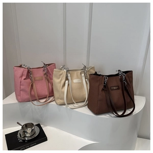 Three stylish large canvas tote bags in pink, beige and brown with metal chain straps