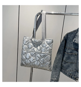Silver quilted tote bag with metallic finish and grey woven straps for autumn winter
