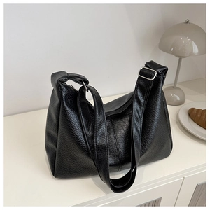 Detail of black large-capacity underarm bag with pleated PU leather texture and silver buckle