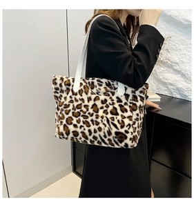 Detail of plush leopard print tote bag with soft faux fur texture and white leather straps