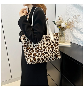 Close-up of plush leopard print tote bag with white leather straps on a model