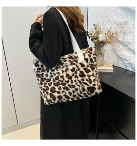 Detail of plush leopard print tote bag with white leather strap on female model
