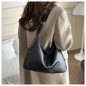 Detail view of black litchi pattern hobo bag worn by model showing large capacity and texture