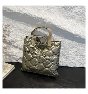 Detail of champagne gold quilted tote bag showing metallic texture and rhombic stitching