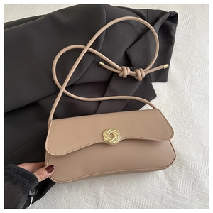 Detailed close-up of golden spiral twist metal buckle on the khaki leather shoulder bag