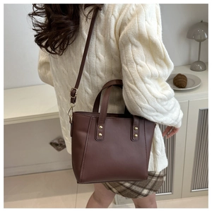 Detail view of dark coffee vintage tote bag with gold rivets and adjustable strap