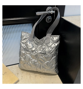 Detail view of silver quilted tote bag showing rhombus stitching and fabric texture