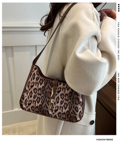 Détail du sac sous le bras à motif léopard avec fermoir doré et bandoulière brune