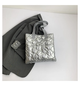 Detail of silver quilted tote bag with metallic finish and padded rhombic patterns