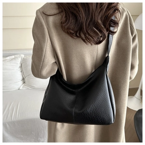Detailed view of the black textured hobo bag worn with an elegant wool coat for commute