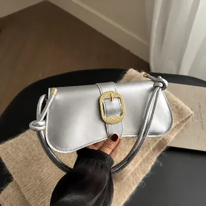 Dettaglio borsa sottobraccio in pelle argentata con fibbia dorata ovale