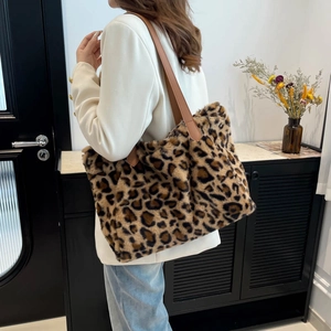 Plush leopard print tote bag with brown leather straps shown on model for winter fashion