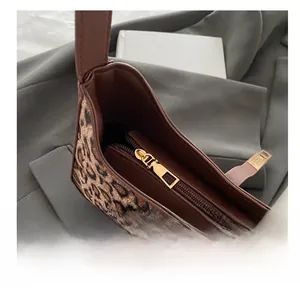Vue détaillée de la fermeture éclair en métal doré sur le sac à imprimé léopard
