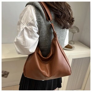 Brown faux leather hobo bag with lychee texture and wide adjustable shoulder strap