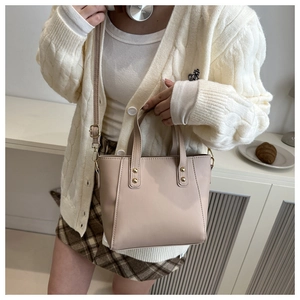 Detailed shot of beige retro tote bag with golden rivets in a minimalist lifestyle setting