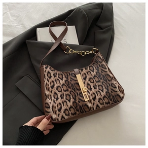 Detail showing leopard print faux fur texture with brown leather trim and gold chain